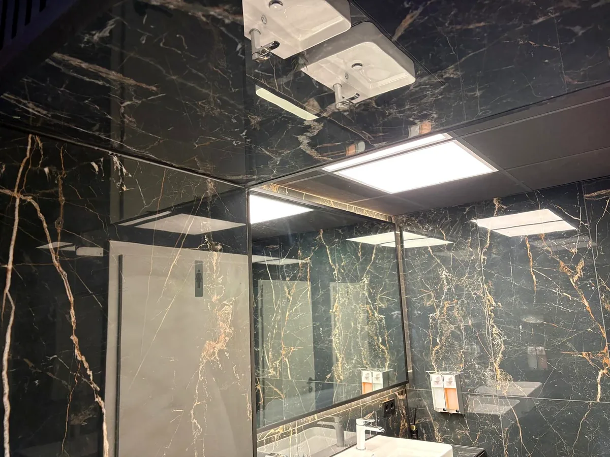 Hochwertig ausgebauter Sanitärbereich mit Fliesen sowie Wand- und Deckenoberflächen.