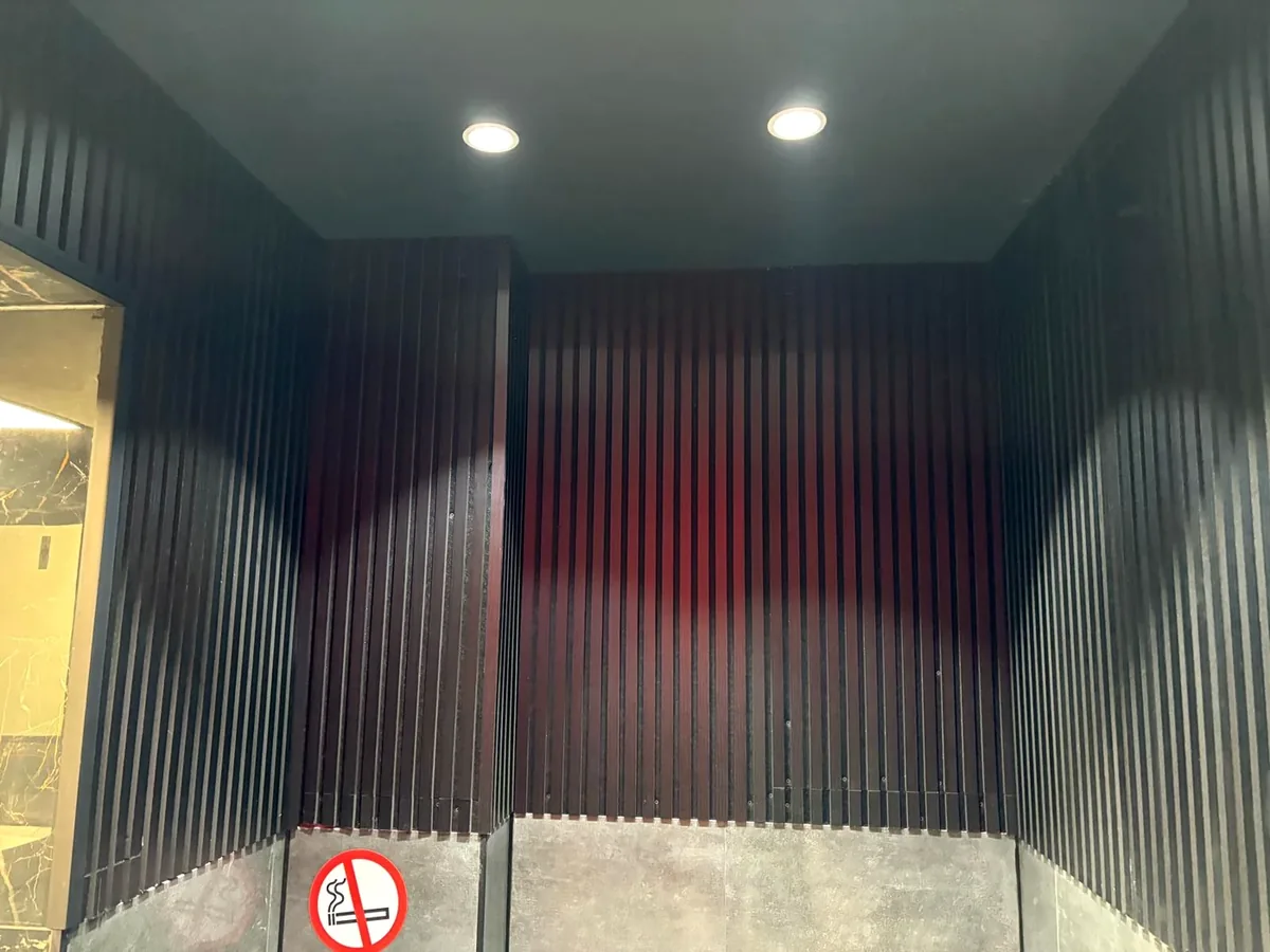 Nische mit dunkler Wandverkleidung und dezenten roten Lichtakzenten.