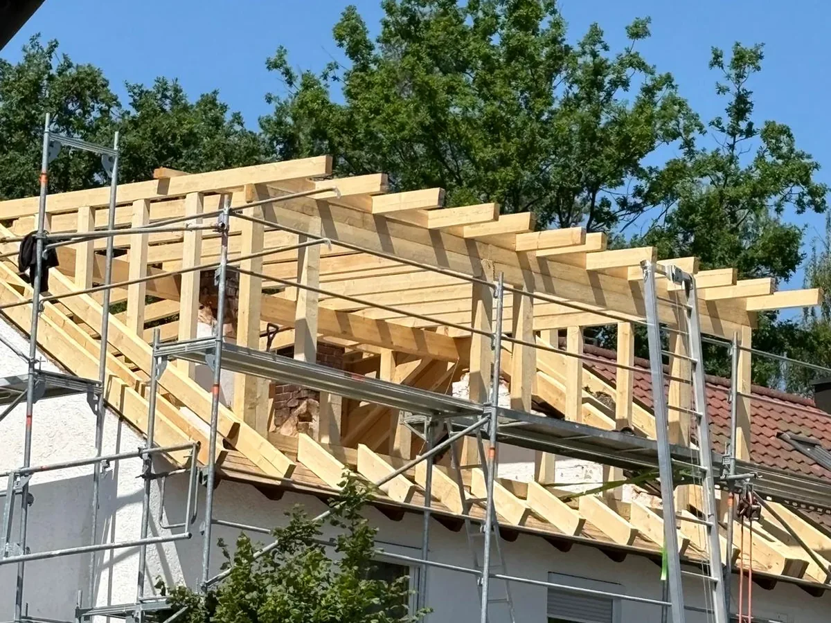 Dachkonstruktion mit Holzsparren und Gerüst von außen.