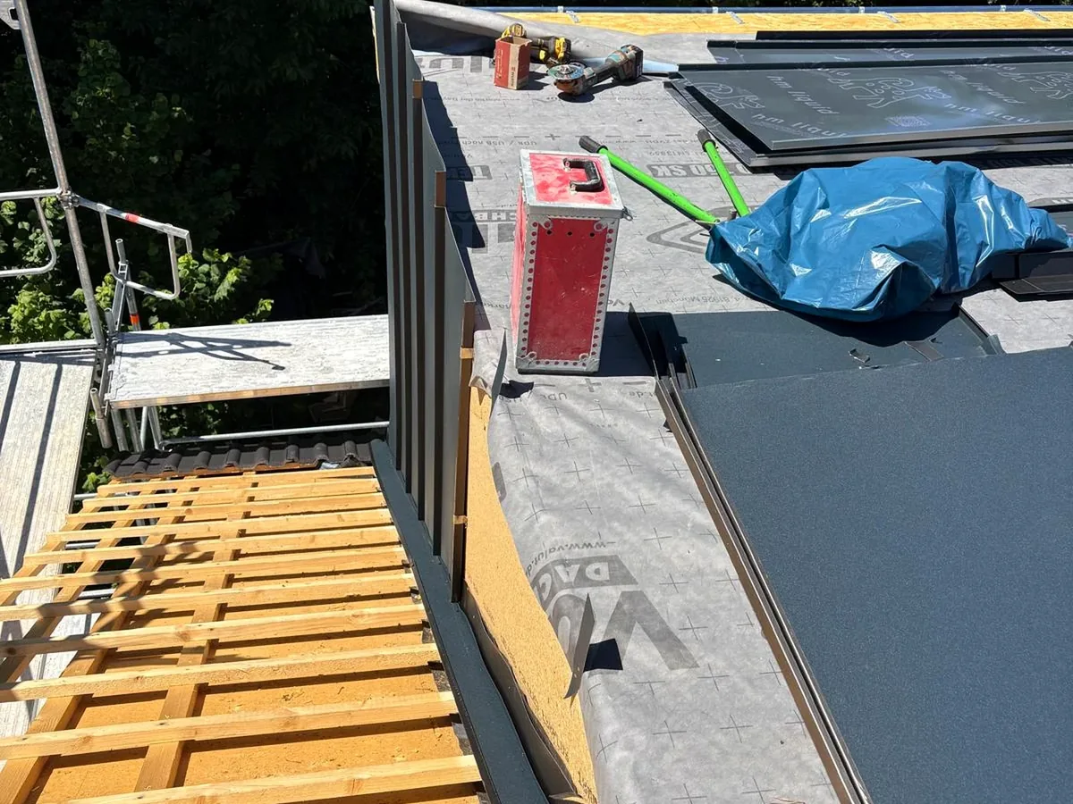 Übergang von Dachunterkonstruktion zu dunkler Metallbedachung.