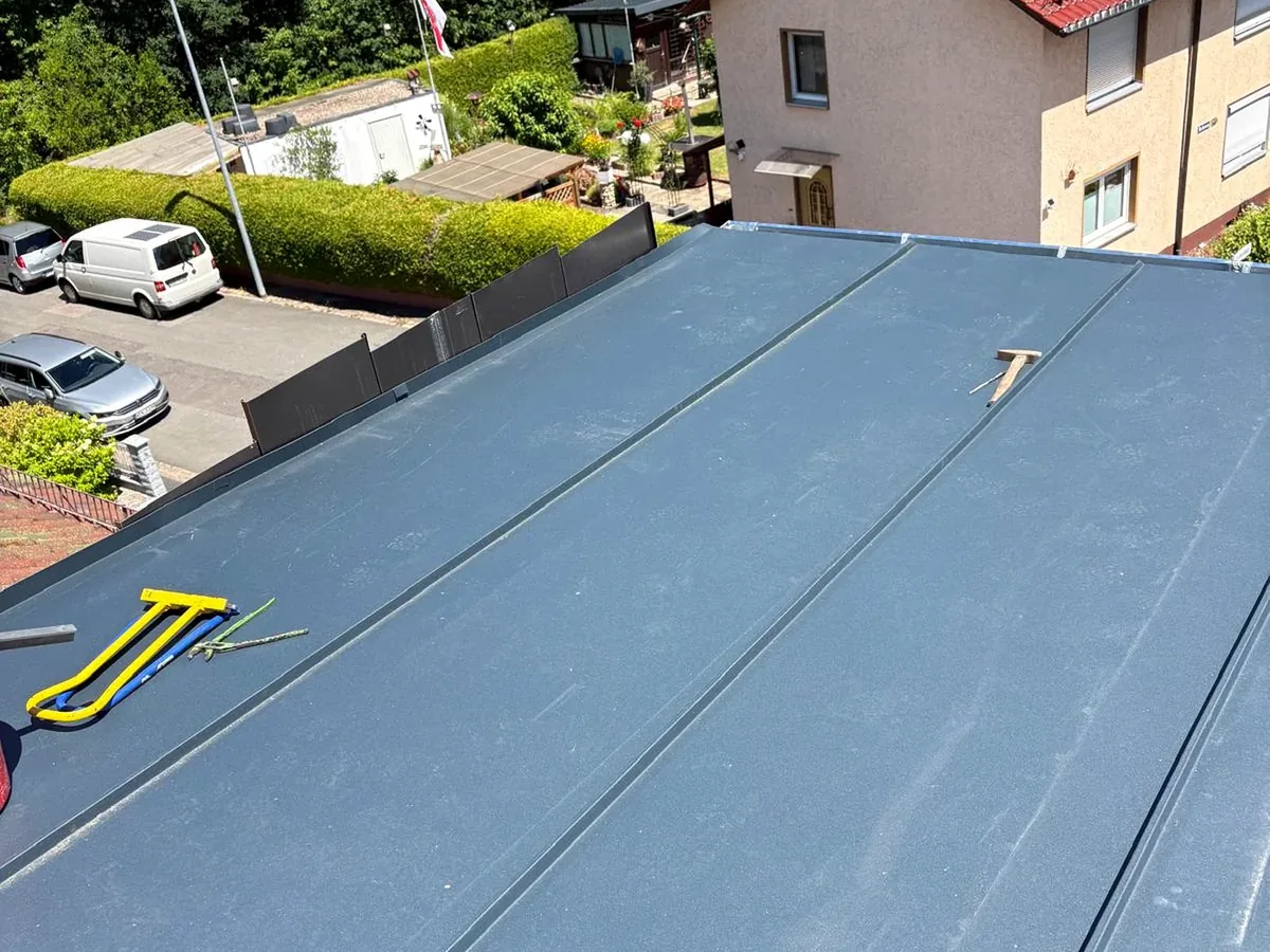 Fertiggestellte dunkle Metallbedachung auf einem Dach.